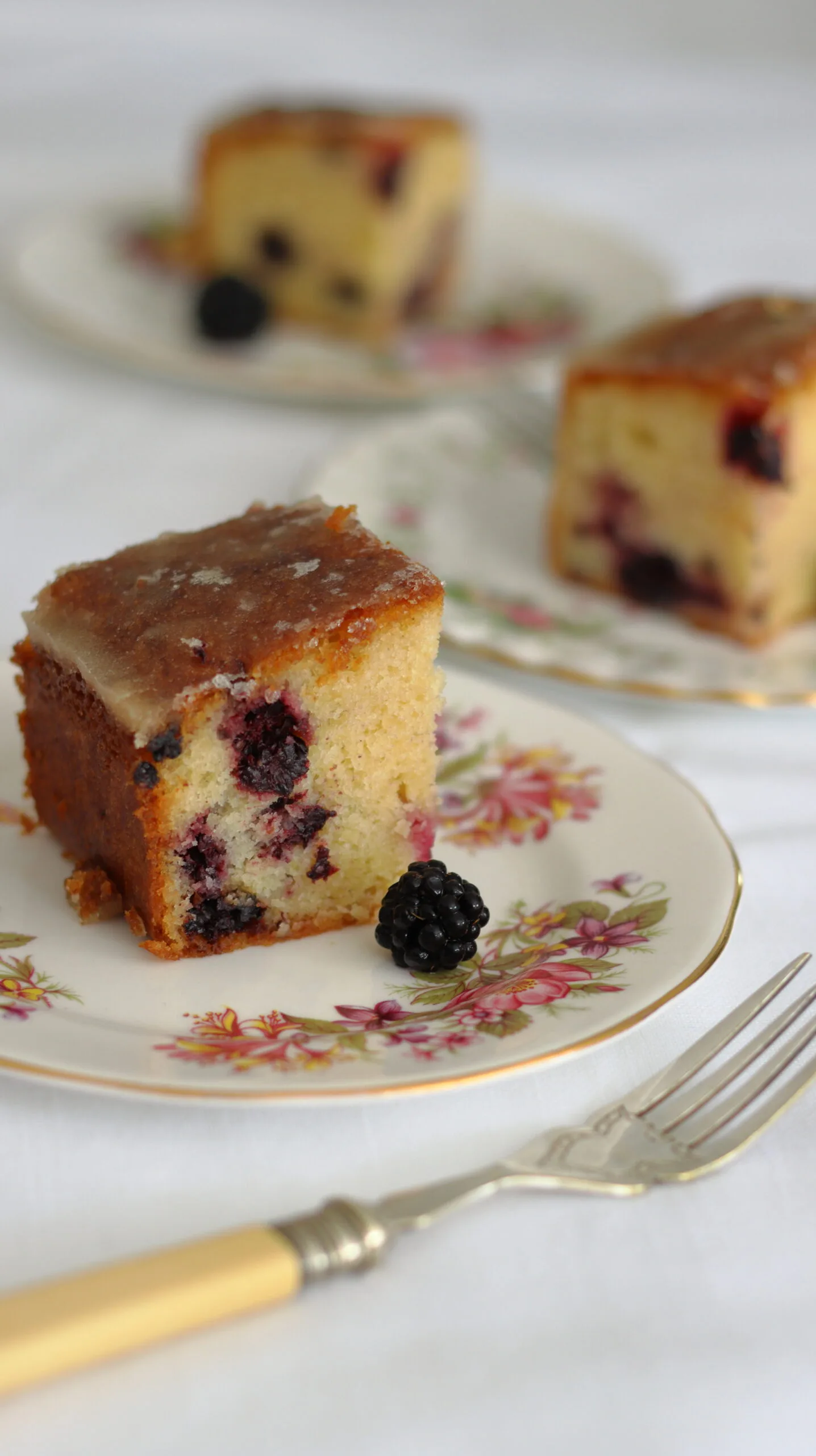 slices of blackberry and lemon drizzle cake on plates
