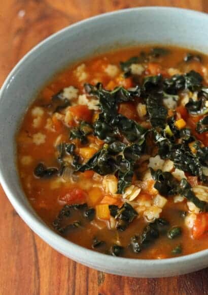 A steaming bowl of chunky Italian minestrone soup with kale and beans