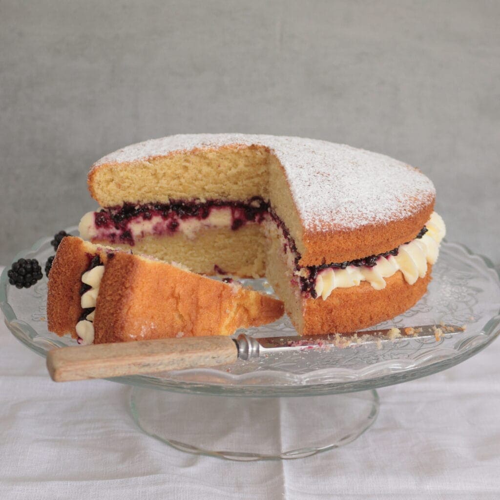 Victoria Sponge on a stand filled with cream and Blackberry jam