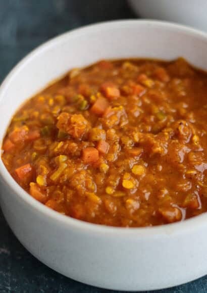 a golden orange bowl of hearty creamy lentil and carrot soup