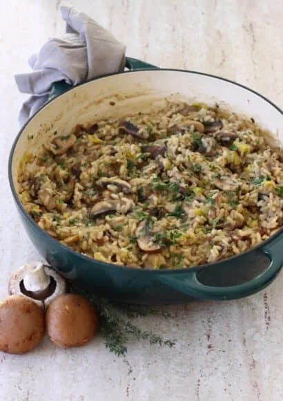 A casserole dish of creamy mushroom and leek risotto topped with parsley ready to serve up.
